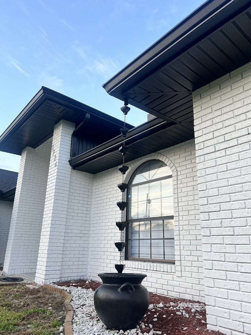Seamless black gutter and downspout on a white brick home, Deltona FL